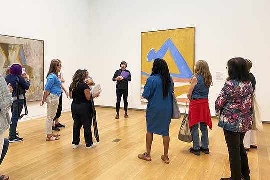 Educators view a painting on a gallery tour. 