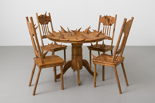 a wooden sculpture of a table and chairs