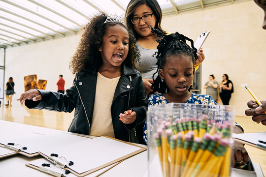 A family sketches during Free First Saturday