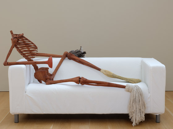 installation image of 'Laure', a sculpture of a wood skeleton with tools for hands and feet