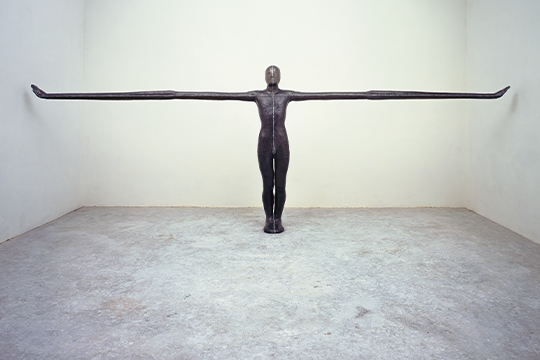 sculpture of a figure touching wall to wall
